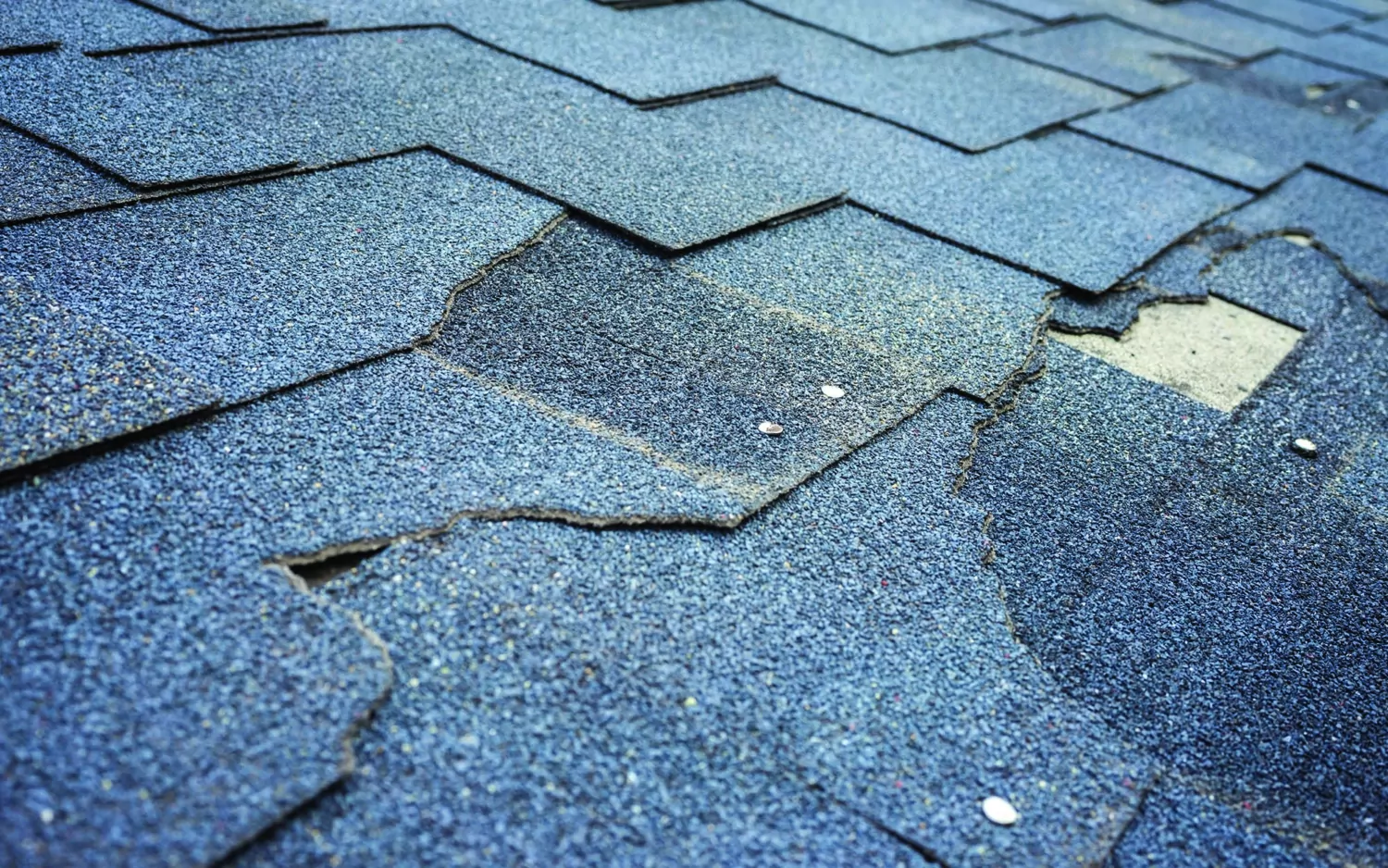 Close-up-image-of-damaged-shingle-roof-1500x938