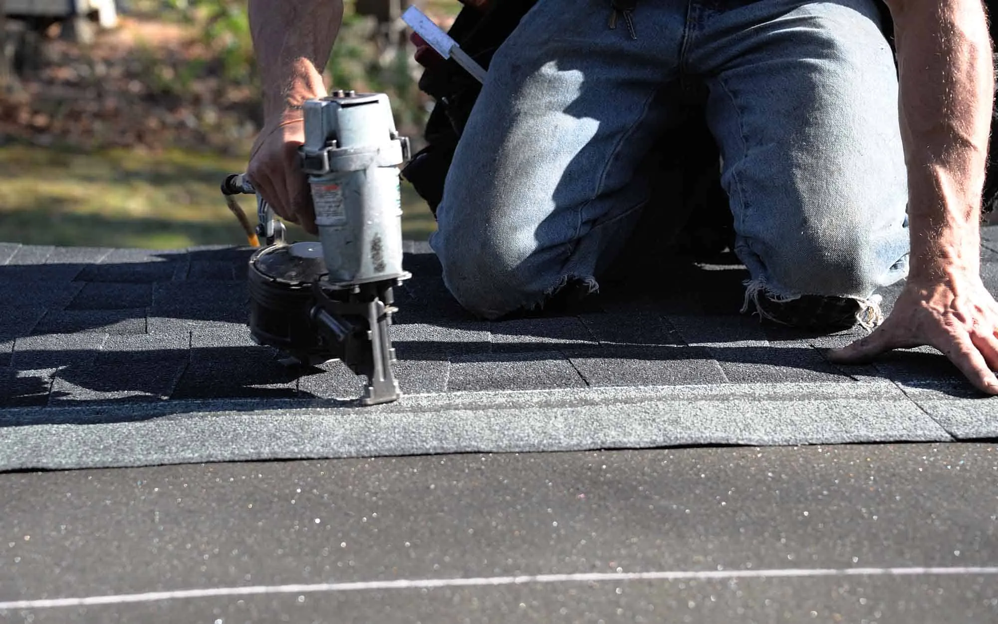 roofer-on-knees-using-nail-gun